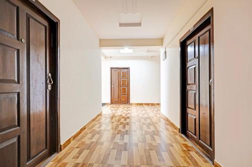 an empty hallway with two doors and wooden floors at Super Collection O Beach Road Near GITAM in Visakhapatnam