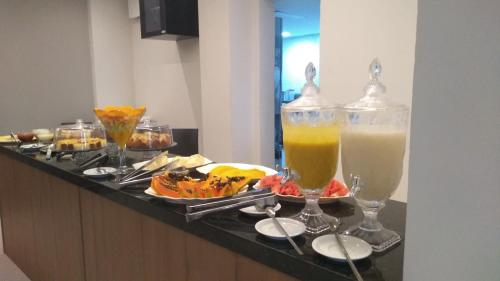 a buffet with two drinks and plates of food at Amazon Seasons hotel in Belém