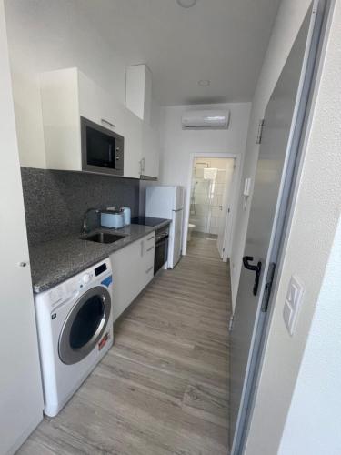 a kitchen with a washer and dryer in a room at Lord Freitas in Funchal