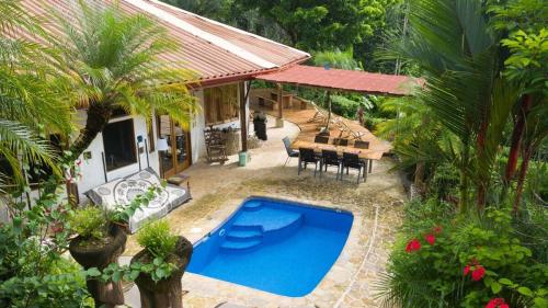 Una casa con una piscina azul al lado de una mesa. en Paradiselodge - Poolvilla, en Platanillo