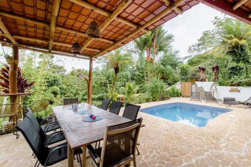 a patio with a table and chairs and a pool at Poolvilla in Platanillo