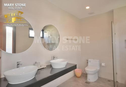 um banheiro com duas pias, um vaso sanitário e um espelho em Villa Baya - 3BR Modern Poolside em Bangrak Beach