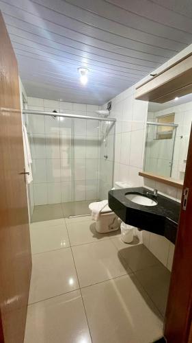 ein Badezimmer mit Glasdusche und Toilette in der Unterkunft Hotel Lux in Poços de Caldas