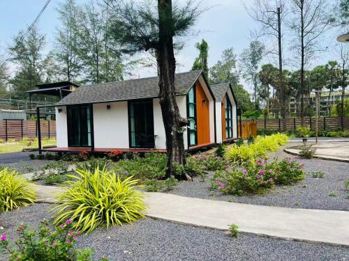 a small house with a tree in a garden at Sandline Cabin Bangtao Just 20m from the Beach in Bang Tao Beach