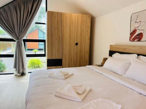 a bedroom with a bed with two folded towels on it at Sandline Cabin Bangtao Just 20m from the Beach in Bang Tao Beach
