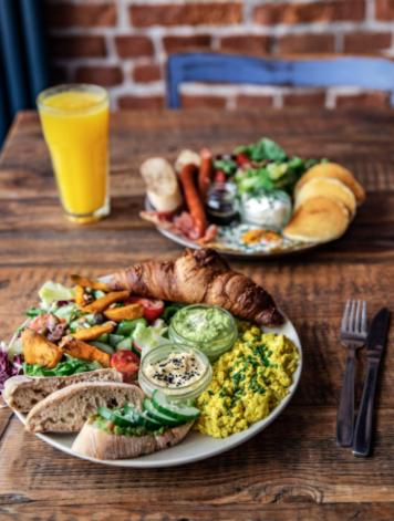 twee borden eten op een houten tafel met sinaasappelsap bij Cozy Corner by Cozyplace in Krakau