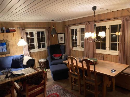 een woonkamer met een tafel en een blauwe bank bij Golsfjellet in Gol