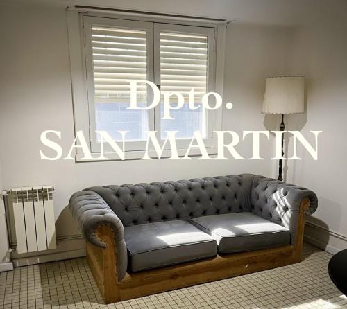 a couch sitting in a room with a window at Dpto SAN MARTIN in Azul
