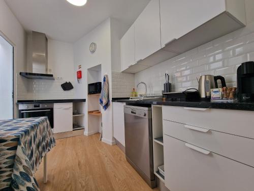 a kitchen with white cabinets and a counter top at Market Downtown T3 in Funchal