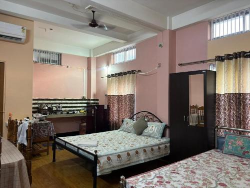 two beds in a room with pink walls at Sarojinilaya Homestay in Guwahati