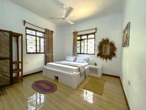 a bedroom with a white bed in a room at Tropical Paje Home with Pool Near the Beach in Paje