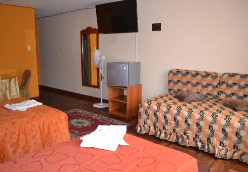 ein Wohnzimmer mit einem Sofa und einem TV in der Unterkunft Hostal Bona Nit in Trujillo