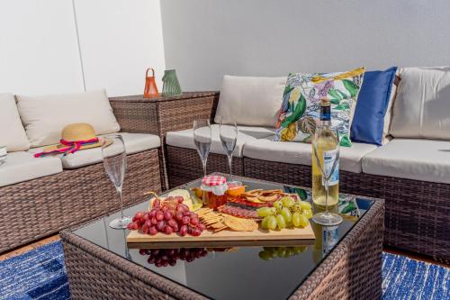 a table with a tray of food and a bottle of wine at Moradia São João-Spacious Beachfront Villa in A dos Cunhados
