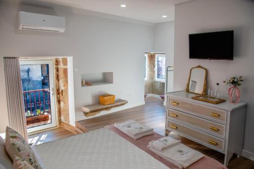 ein Schlafzimmer mit einem Bett und einer Kommode mit einem Fernseher in der Unterkunft Villa Jerusalém - Casa de Campo in Avantos