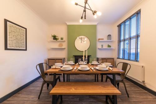a dining room with a wooden table and chairs at 4 bedroom 2 bath beautiful Victorian house in Nottingham