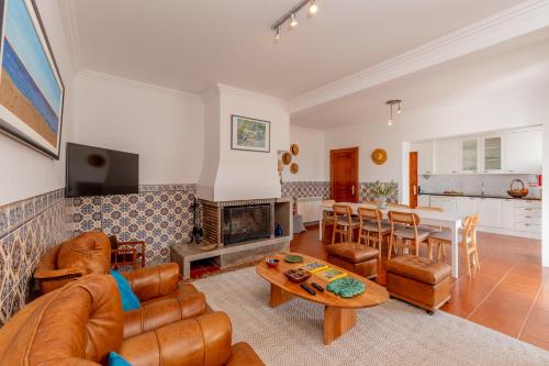 a living room with a couch and a table at Moradia São João-Spacious Beachfront Villa in A dos Cunhados
