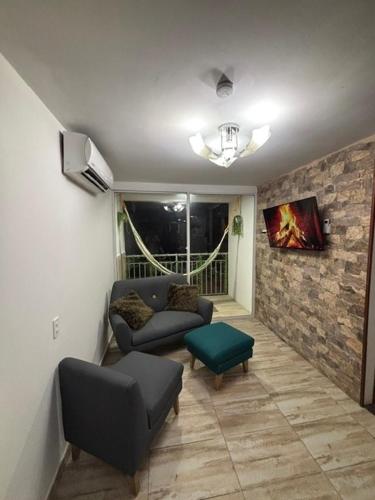 a living room with two chairs and a couch and a table at BAM - Hospedajes in Santa Marta