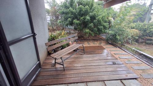 un banco sentado en una terraza de madera junto a un edificio en Ti kaz Amater Cascavelle, en Cascavelle