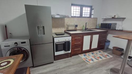 a kitchen with a stove and a sink and a washer at Ti kaz Amater Cascavelle in Cascavelle