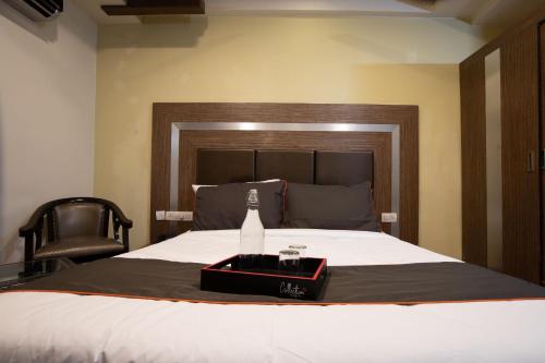 a bottle of champagne on a bed with a chair at Hotel O DG College Chelambra in Ferokh