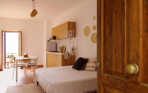 a small bedroom with a bed and a kitchen at Lumira Vista – Panorama in Sangineto