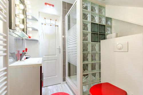 a bathroom with a red stool in front of a glass wall at La Maison Mazarin in Chilly-Mazarin