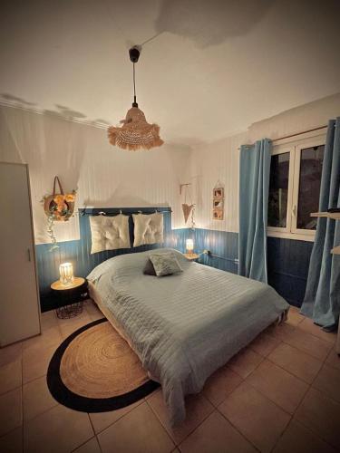 a bedroom with a large bed and a chandelier at Cascade et Paille-en-queue - Studio in Hell-Bourg