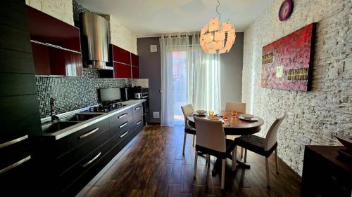 a kitchen with a table and chairs in a kitchen at Nizzeti Home Catania Sicily Sea View in Aci Catena