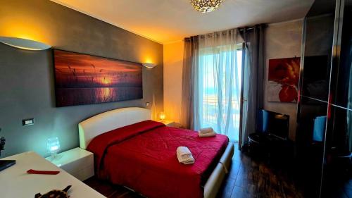 a bedroom with a red bed and a window at Nizzeti Home Catania Sicily Sea View in Aci Catena