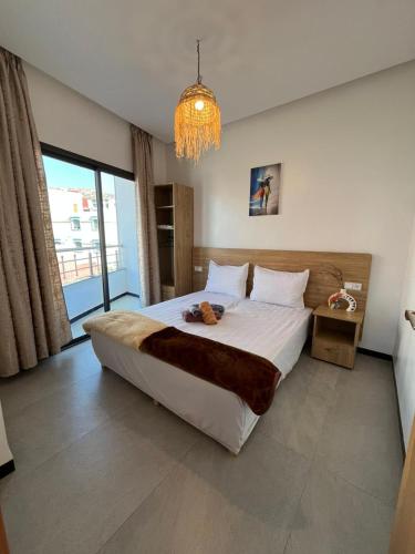 a bedroom with a large bed and a chandelier at Atlantic view Tamraght 1 in Tamraght Oufella