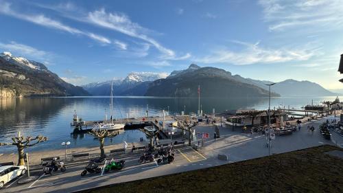 a view of a lake with mountains and a dock at Erholung am Vierwaldstättersee, komfortables 3-Bett-Zimmer in Brunnen in Brunnen