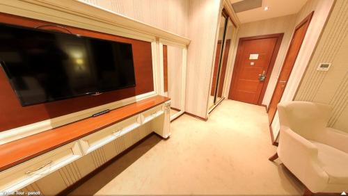 a living room with a large flat screen tv on a wall at Boulevard Side Hotel in Baku