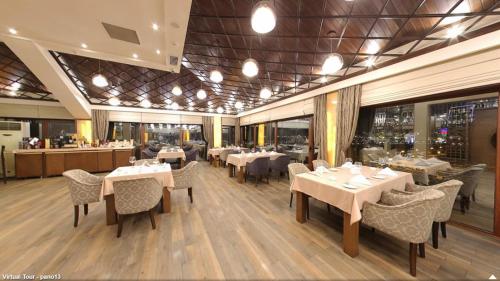 a dining room with tables and chairs in a restaurant at Boulevard Side Hotel in Baku
