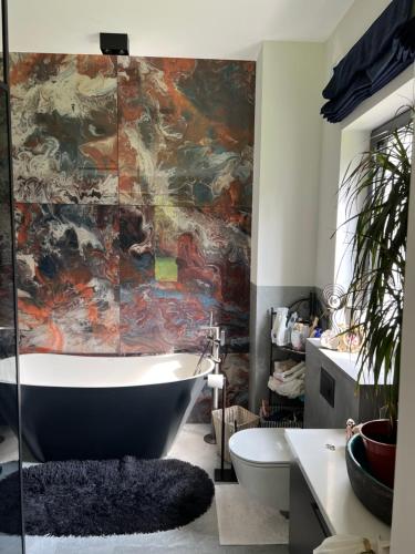 une salle de bain avec une baignoire et un tableau au mur dans l'établissement Modern Villa Located in the Heart of Konstancin-Jeziorna, à Konstancin-Jeziorna