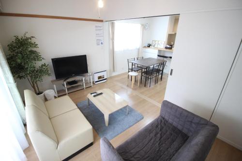 a living room with a couch and a table at Guesthouse徳島201 in Tokushima