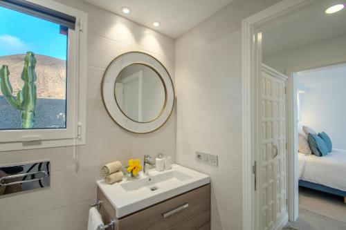 a bathroom with a sink and a mirror and a bed at Villa Katya by Villalize in Teguise