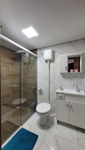 a bathroom with a toilet and a shower and a sink at Garagem 36 próximo a Serra do Rio do Rastro in Louro Müller