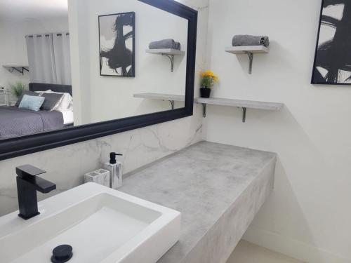 ein Badezimmer mit Waschbecken und Spiegel in der Unterkunft Kevin#B Chic Studio with Patio near Fort Lauderdale Beach in Fort Lauderdale