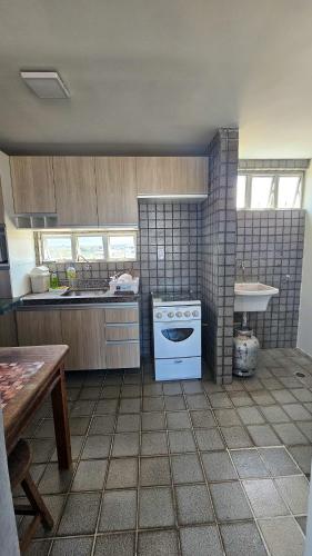 a kitchen with a stove and a sink at Refúgio próximo ao mar in Cabedelo