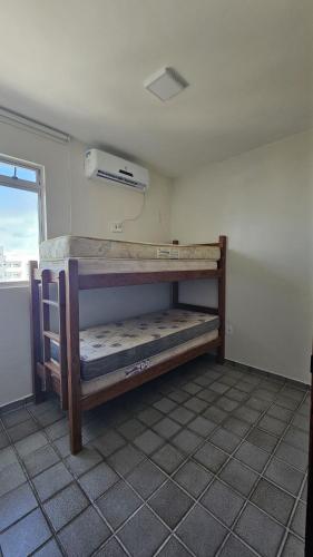 a room with two bunk beds in a room with a window at Refúgio próximo ao mar in Cabedelo