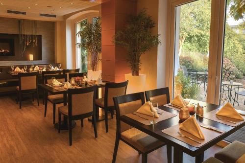 a restaurant with tables and chairs and a large window at Römerhof in Stuttgart