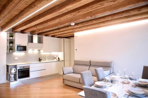 a dining room with a table and chairs and a kitchen at Udine Urban Nest in Udine
