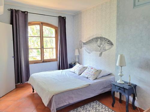 1 dormitorio con 1 cama con un pez en la pared en BASTIDE PRESQU ILE DE GIENS SUPERBE VUE MER PISCINE, en Hyères