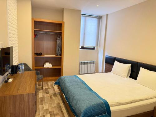 a bedroom with a bed and a desk and a window at Briiz Hotel Baku in Baku