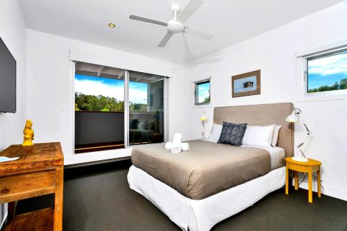 a bedroom with a bed and a window at Stonecutters 2 in Byron Bay