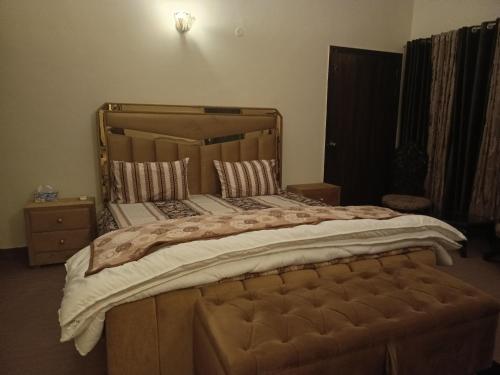een slaapkamer met een groot bed met een houten frame bij The Residency in Islamabad