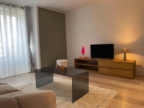 a living room with a coffee table and a television at l'Onyx in La Rochelle