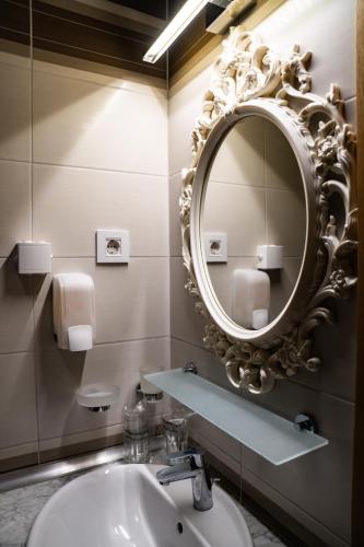 a bathroom with a sink and a mirror at Miznah Hotels & Resorts in Bačka Topola