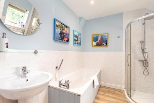 a white bathroom with a sink and a shower at Poachers Lodge At Tapnell Farm in Yarmouth