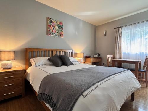 a bedroom with a bed and a table with chairs at Orchard Cottage in Willingham
